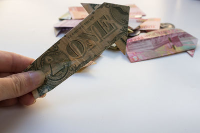 Cropped hand holding paper currency against white background