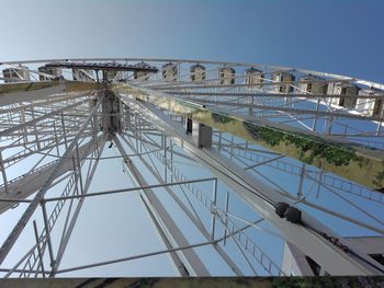 Low angle view of ferris wheel against clear blue sky