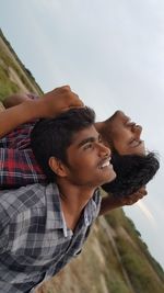 Young couple kissing against sky