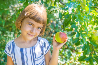 Portrait of young woman holding apple