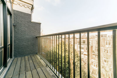 Part of balcony with metal railing in residential apartment building on sunny day