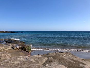 Scenic view of sea against clear blue sky