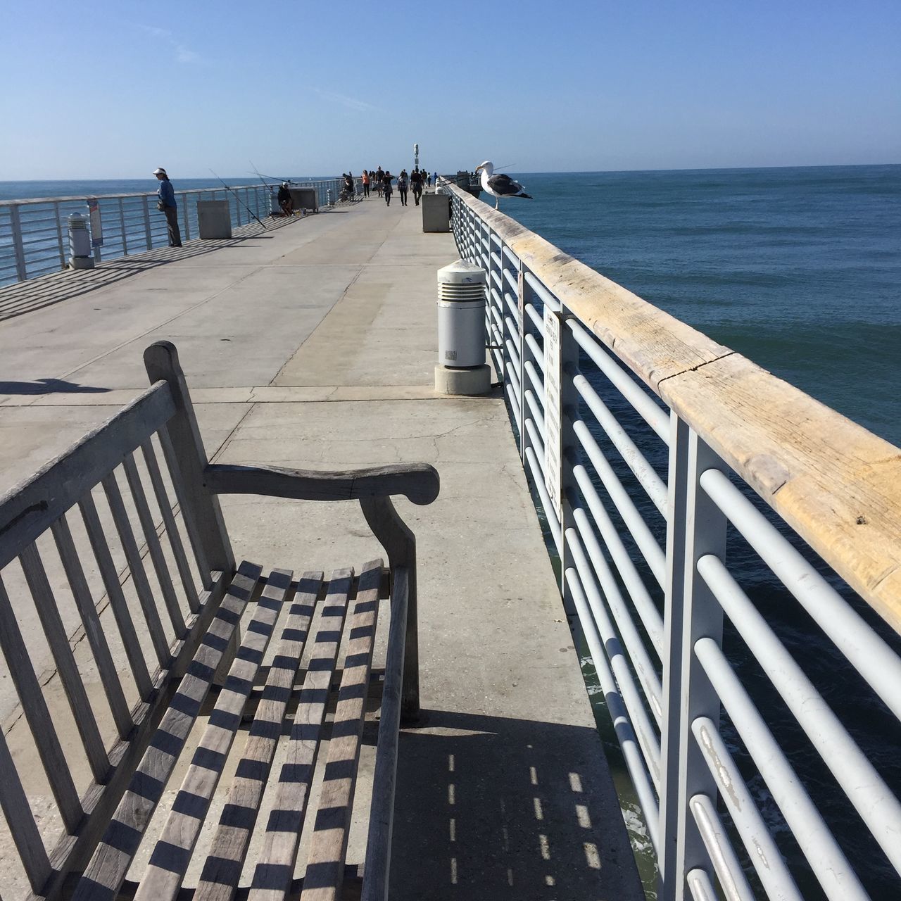 architecture, built structure, building exterior, water, sunlight, steps, building, shadow, railing, city, sky, day, staircase, clear sky, outdoors, sea, steps and staircases, blue, high angle view, no people