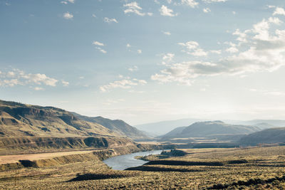 Scenic view of land and mountains against sky