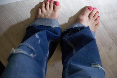 Low section of woman standing on hardwood floor