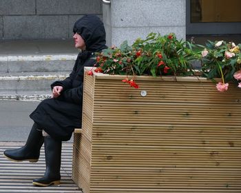 Full length of woman sitting by plants