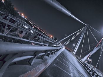 Low angle view of illuminated bridge against sky at night