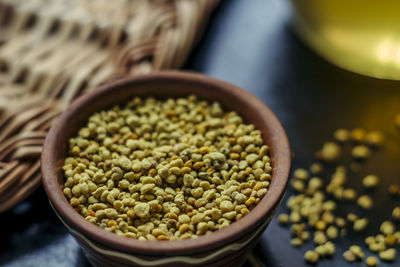 Close-up of yellow bee pollens in bowl on table