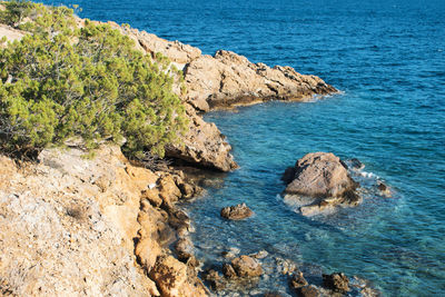 High angle view of rocks on sea shore