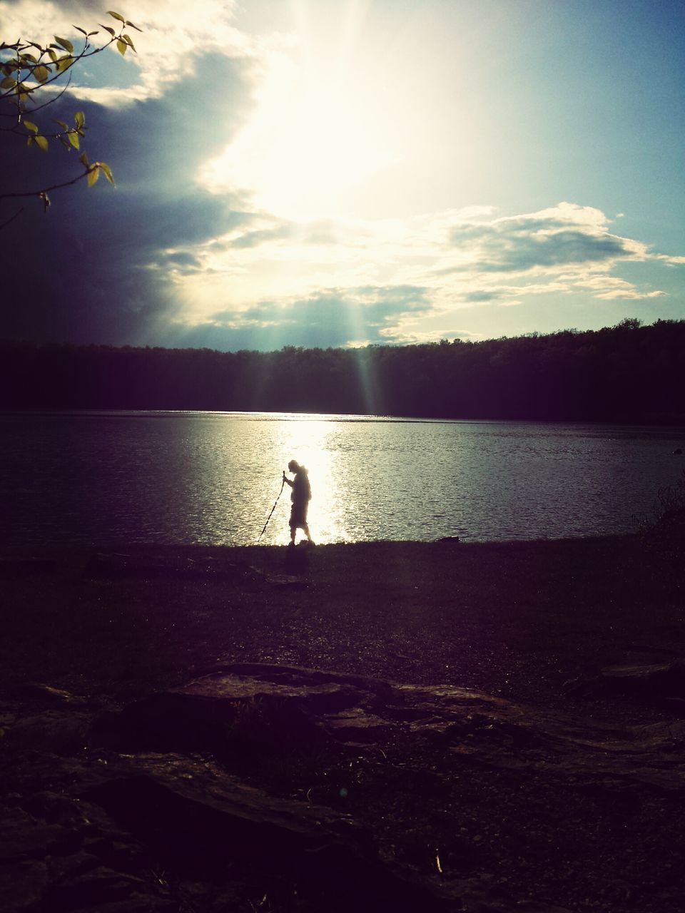 water, silhouette, sky, tranquil scene, leisure activity, tranquility, lifestyles, reflection, lake, beauty in nature, scenics, nature, men, sunlight, sunset, standing, full length, sea