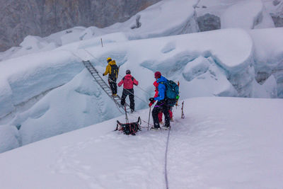 People skiing on snowcapped mountains during winter