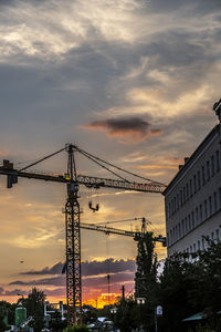 Construction cranes at sunset