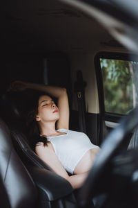 Portrait of young woman sitting in car