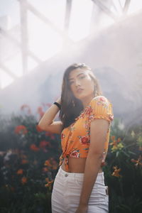 Beautiful woman standing by railing in park