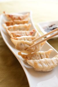 Close-up of dumpling in chopsticks at table