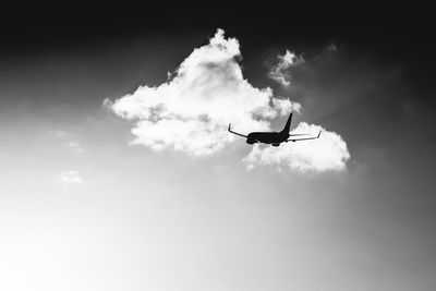 Low angle view of silhouette airplane against sky