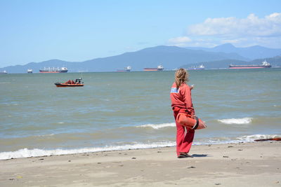 Rear view of lifeguard standing on beach