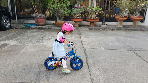 Full length of woman riding bicycle on street