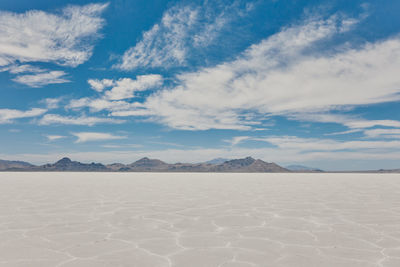 Scenic view of desert against cloudy sky