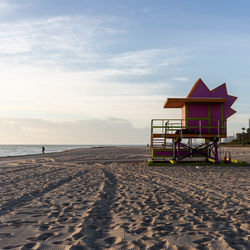 Lifeguard hut at beach against sky