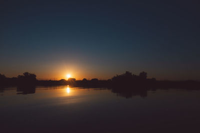 Scenic view of lake against sky during sunset