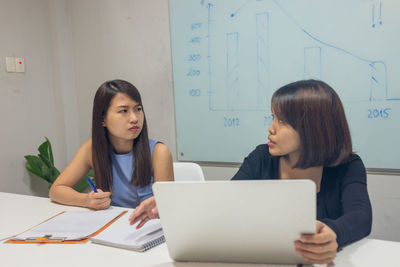 Young woman using laptop at office