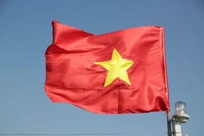 Low angle view of flag against blue sky