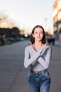 Portrait of young woman gesturing on road