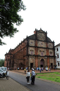 People in front of cathedral against sky in city