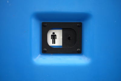 Men room sign on blue metallic wall