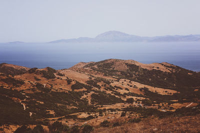 Scenic view of sea and mountains against clear sky