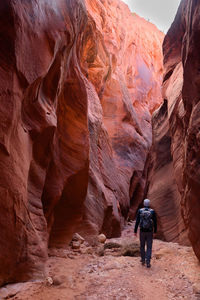 Rear view of man walking on rock formations