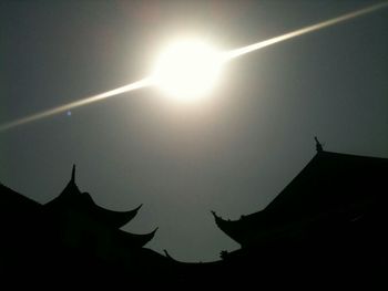 Low angle view of silhouette built structure against sky