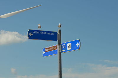 Low angle view of road sign against sky