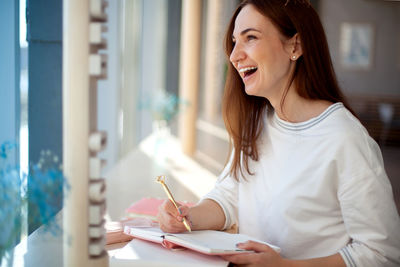 Young woman smiling while sitting in pen