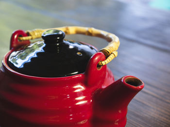 The red chinese teapot on a wooden table, close-up