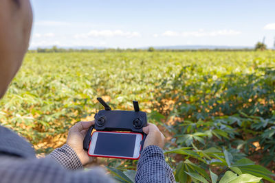 Man photographing with mobile phone in field