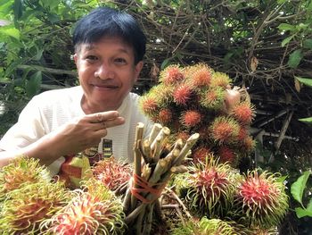 Portrait of smiling man holding flowering plants