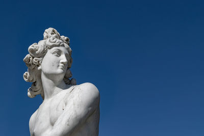 Low angle view of statue against blue sky