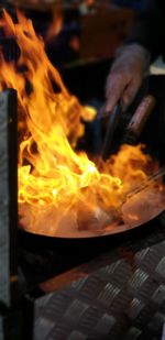 Midsection of person preparing fire on wood