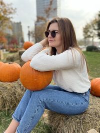 Portrait of young woman wearing sunglasses while sitting on field