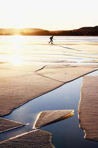 Woman ice-skating, ice floe on foreground