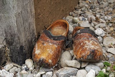 High angle view of dirty wooden shoes on rocks