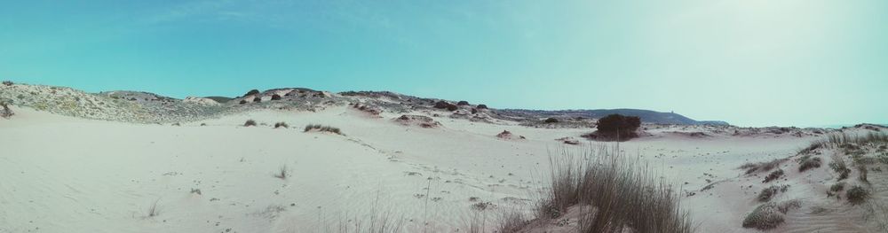 Panoramic view of desert against clear blue sky