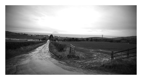 Road by landscape against sky