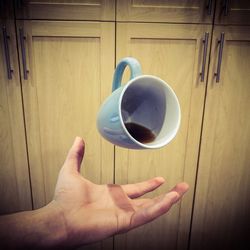 Hand catching coffee cup