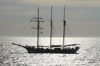 Sailboats in sea against sky