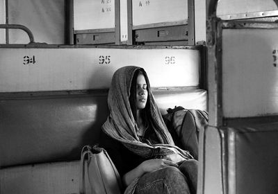 Young woman with eyes closed sitting in train