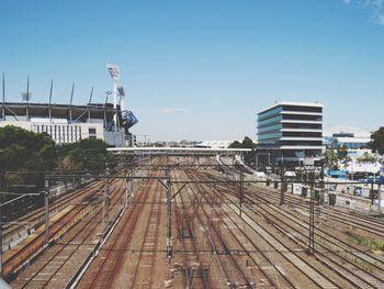 Railroad tracks in city against clear sky