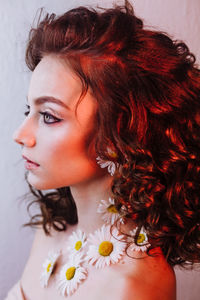 Close-up of beautiful young woman wearing flowers and make-up